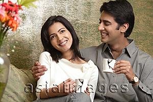 Asia Images Group - laughing couple holding tea cups