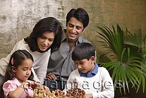Asia Images Group - family look at chess set
