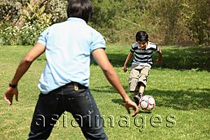 Asia Images Group - Father and son kicking soccer ball