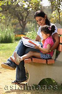Asia Images Group - Mother and daughter reading on park bench