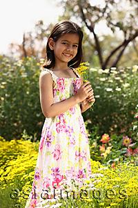 Asia Images Group - Little girl standing with yellow flowers