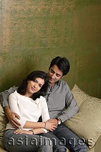 Asia Images Group - couple sit on couch, she rests head on his shoulder