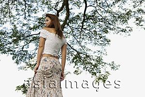 Asia Images Group - Woman standing under tree