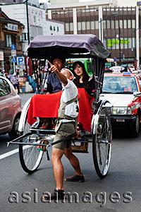 Asia Images Group - Couple taking a rickshaw ride on busy street in Tokyo Asakusa, Japan