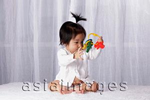 Asia Images Group - Chinese baby looking at toy key ring