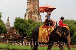 Asia Images Group - tourist riding a elephant in front of stone Wat at Ayutthaya, Thailand
