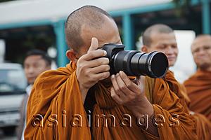 Asia Images Group - Monk taking photos with camera, Bangkok, Thailand
