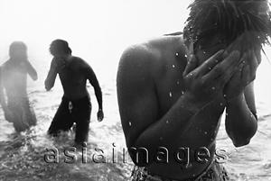 Asia Images Group - Teenagers wading in the ocean