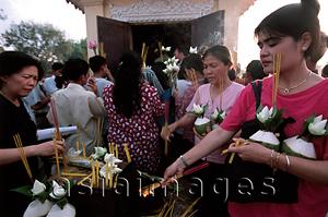 Asia Images Group - Cambodia, Phnom Penh, Mekong River, worshippers offer burnt incense.