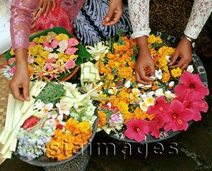 Asia Images Group - Indonesia, Bali, women in traditional costume arranging assorted flowers on plates