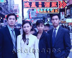 Asia Images Group - Executives standing in a row, busy street in background, portrait.