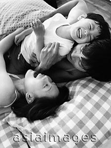 Asia Images Group - Family playing in bed, laughing