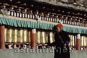 Asia Images Group - China, Szechuan (Sichuan), Kham region, Tibetan woman making kora with prayer wheels.