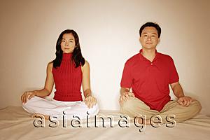 Asia Images Group - Man and woman sitting side by side, legs crossed