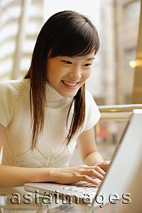 Asia Images Group - Young woman using laptop, smiling