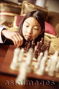 Asia Images Group - Girl playing with chess set