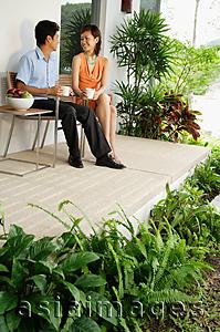 Asia Images Group - Couple sitting and having coffee on patio