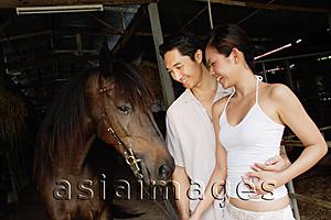 Asia Images Group - Couple with horse in stable
