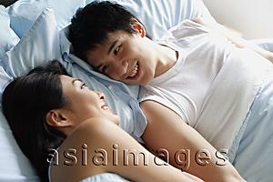 Asia Images Group - Couple in bed, looking at each other, smiling