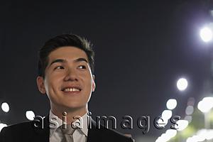 Asia Images Group - Head shot of smiling young man at night