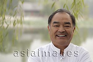 Asia Images Group - Head shot of older man smiling at camera, outdoors