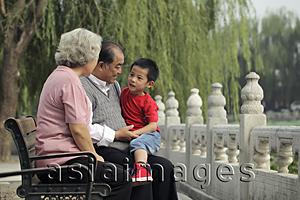 Asia Images Group - Grandparents talking with their grandson in a park