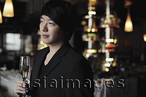 Asia Images Group - Profile of young man holding a glass of champagne.