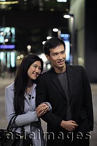 Asia Images Group - Young couple walking on the street at night