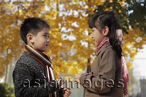 Asia Images Group - Young boy and girl wearing scarfs looking at each other