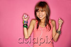 AsiaPix - Young woman smiling, listening to mp3 player