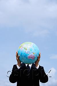 AsiaPix - Businessman holding globe in front of his face