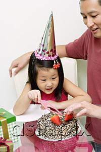 AsiaPix - Father and daughter in front of birthday cake, daughter holding cake knife