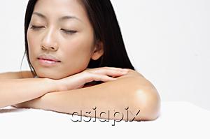 AsiaPix - Woman resting head on arms, eyes closed