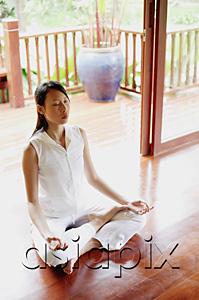AsiaPix - Woman practicing yoga, sitting in lotus position