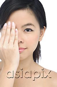 AsiaPix - Young woman covering half her face with her hand