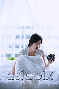 AsiaPix - Woman in bed, looking at alarm clock, mouth open