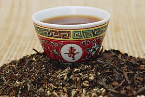 AsiaPix - Chinese teacup and pile of loose tea leaves