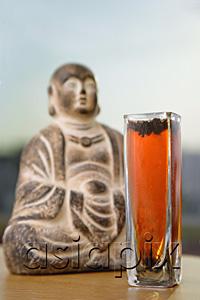 AsiaPix - Glass with Tea next to Buddha icon, selective focus