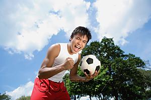 AsiaPix - Young man with soccer ball, looking at camera, hand in a fist