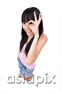 AsiaPix - Young woman making OK sign, looking through fingers