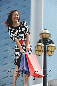 AsiaPix - Woman carrying shopping bags, smiling