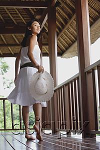 AsiaPix - Young woman in white dress, walking and looking over shoulder