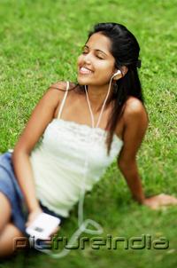 PictureIndia - Young woman listening to music with headphones