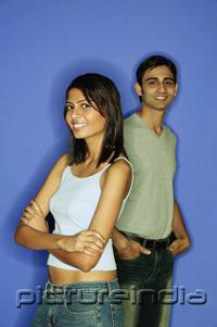 PictureIndia - Woman standing in front of man, arms crossed, man behind with hands in pocket