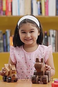 PictureIndia - Young girl with wooden toys, smiling at camera